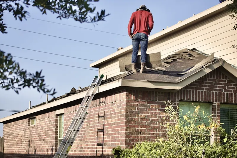 Professional roofer working on a residential roof in Christopher Columbus Homes